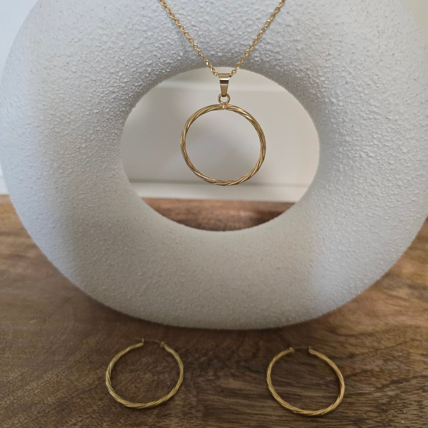 "Elegant gold circle necklace and earring set with a minimalist design, perfect for adding timeless sophistication to any outfit."


